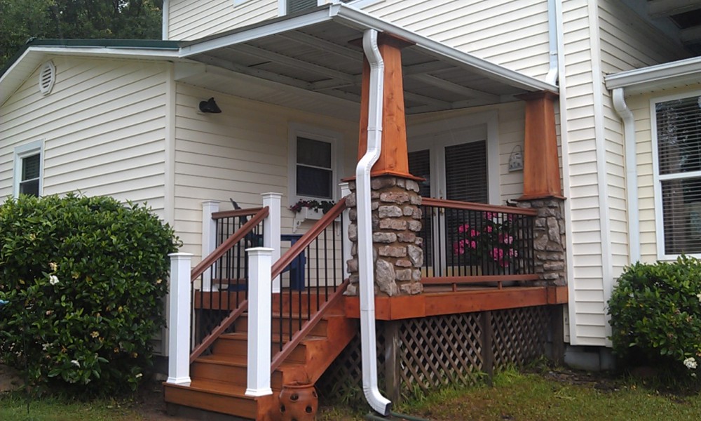 Photo By All American Exteriors. Timbertech Decking, Rails, Stone & Cedar Columns